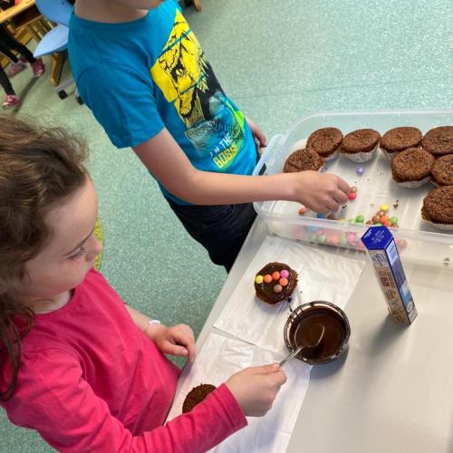 Zwei Kinder beim verzieren ihrer Muffins