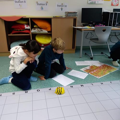 Konzentriert arbeiten 2 Kinder mit den Bee-Bots in Sachunterricht