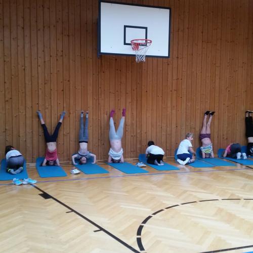 Die Kinder machen einen Kopfstand zur Wand